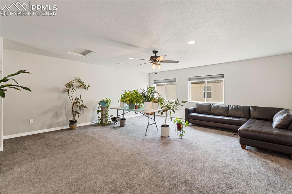 Image 22 of 44: Spacious room featuring neutral carpeting, light gray walls, recessed light