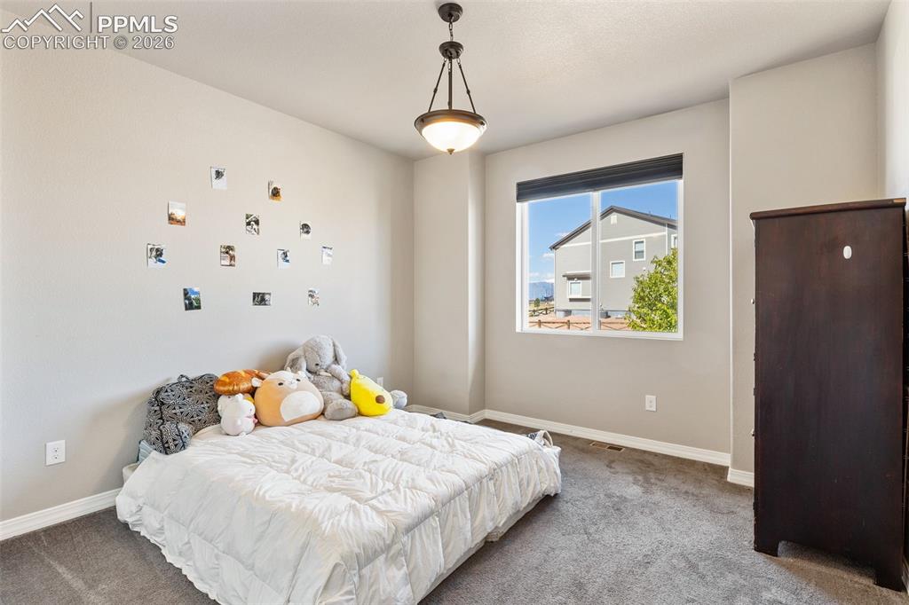 Image 25 of 44: Interior room featuring neutral wall tones and dark gray carpeting
