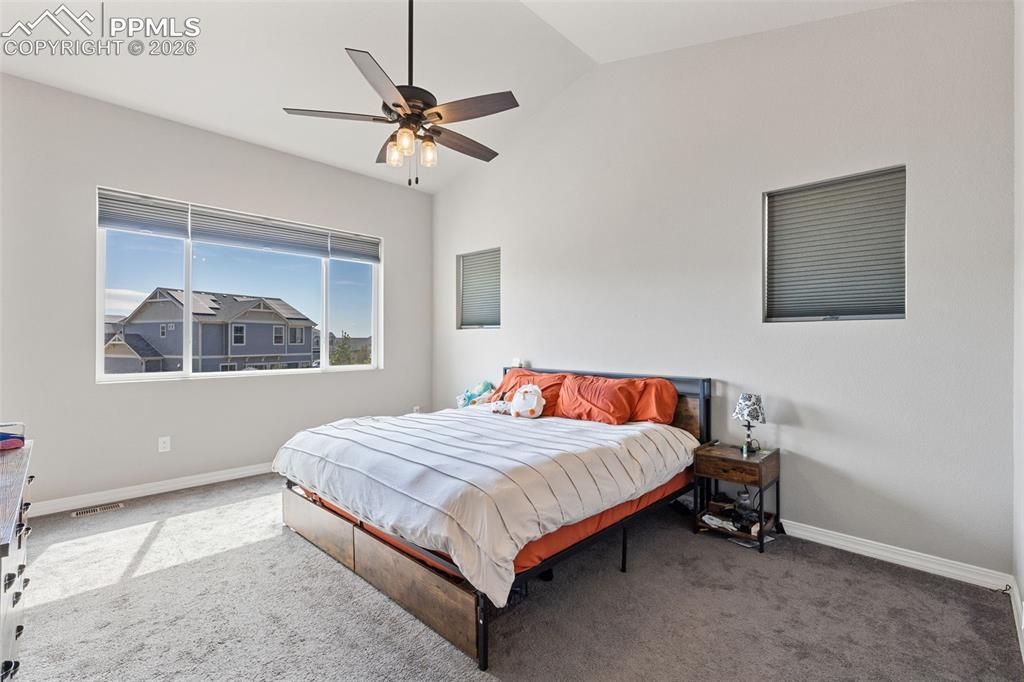 Image 26 of 44: Vaulted ceiling room featuring a wide window, a ceiling fan with integrated