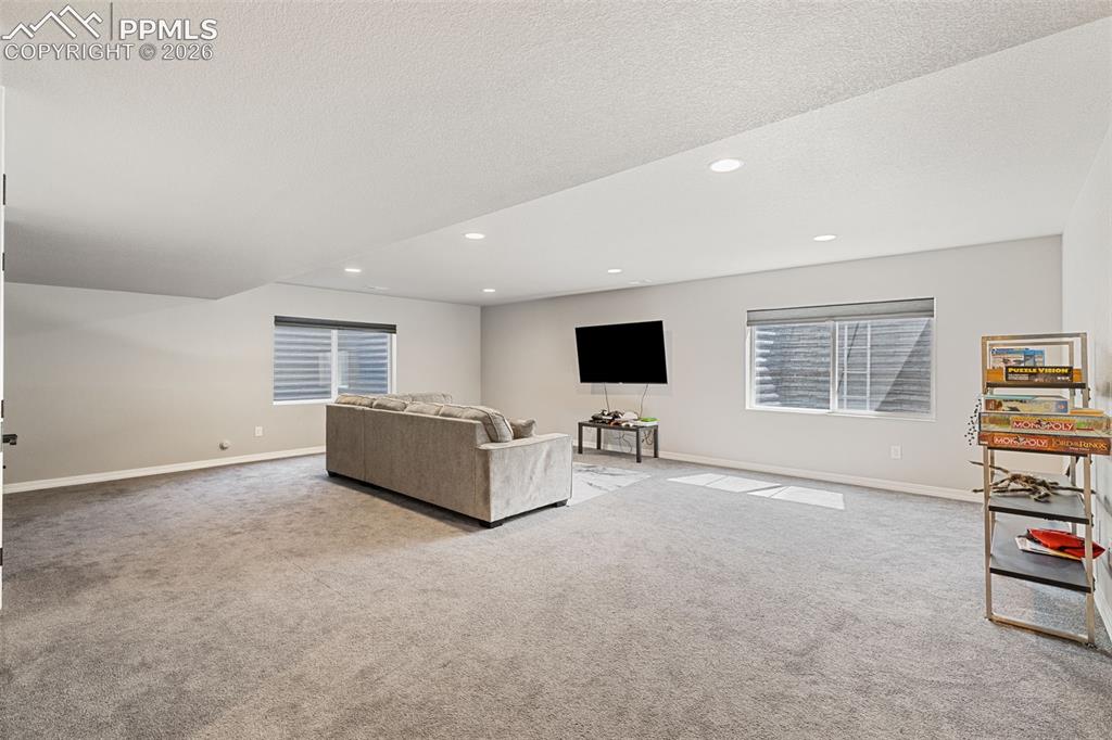 Image 30 of 44: Spacious room featuring neutral carpeting, recessed lighting, and multiple 