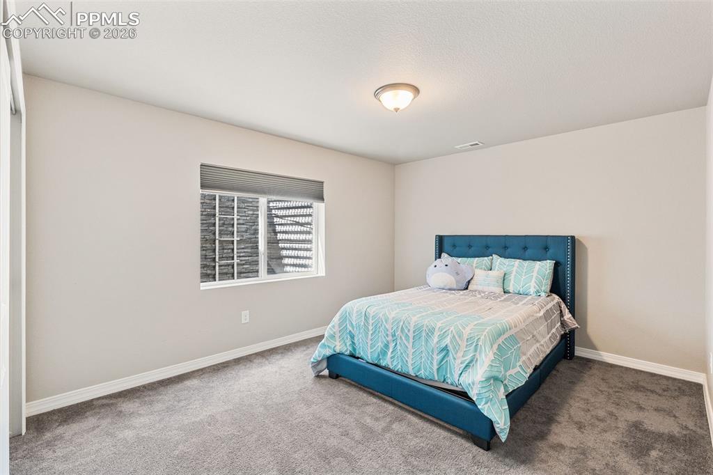 Image 37 of 44: Neutral-toned walls and grey carpet flooring define this room