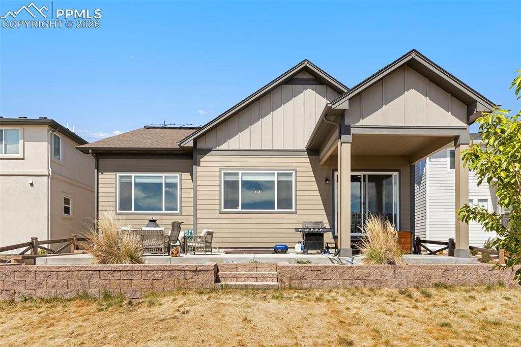 Image 39 of 44: Rear exterior featuring horizontal siding, multiple windows, and a covered 