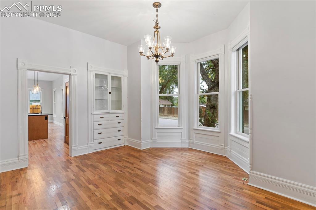 Image 12 of 36: Unfurnished dining area with a chandelier and light wood finished floors