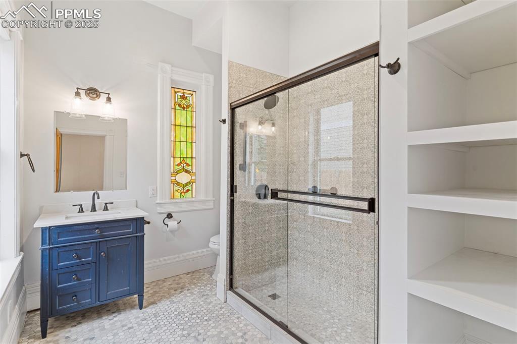 Image 18 of 36: Full bathroom featuring vanity, a shower stall, and light tile patterned fl