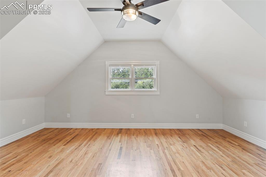 Image 23 of 36: Bonus room featuring light wood finished floors, vaulted ceiling, and a cei