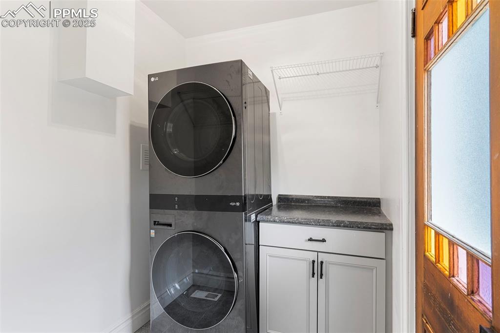Image 26 of 36: Laundry room with estacked washer and dryer and cabinet space