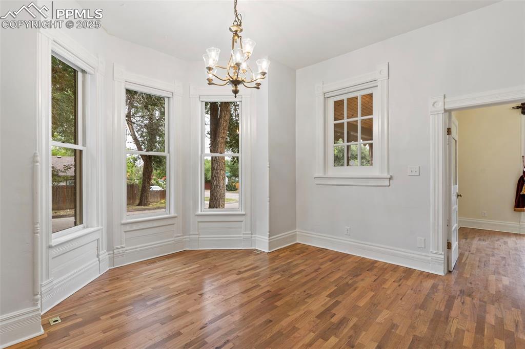 Image 3 of 36: Unfurnished dining area with light wood-style floors and a chandelier