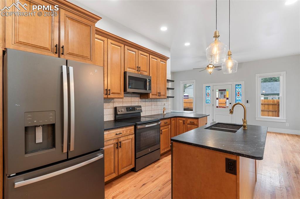 Image 7 of 36: Kitchen featuring appliances with stainless steel finishes, dark countertop