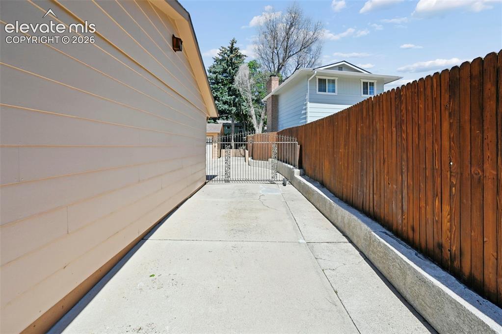 Image 11 of 50: Gated driveway to the back of the home.