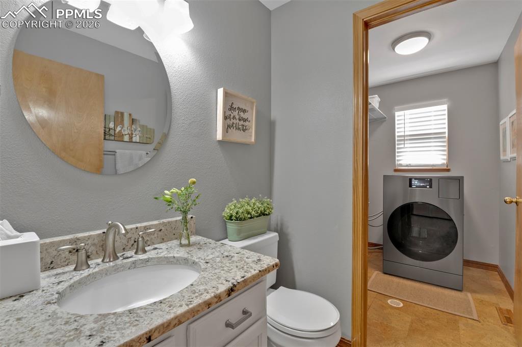 Image 19 of 50: Main level 1/2 bath and Laundry area.