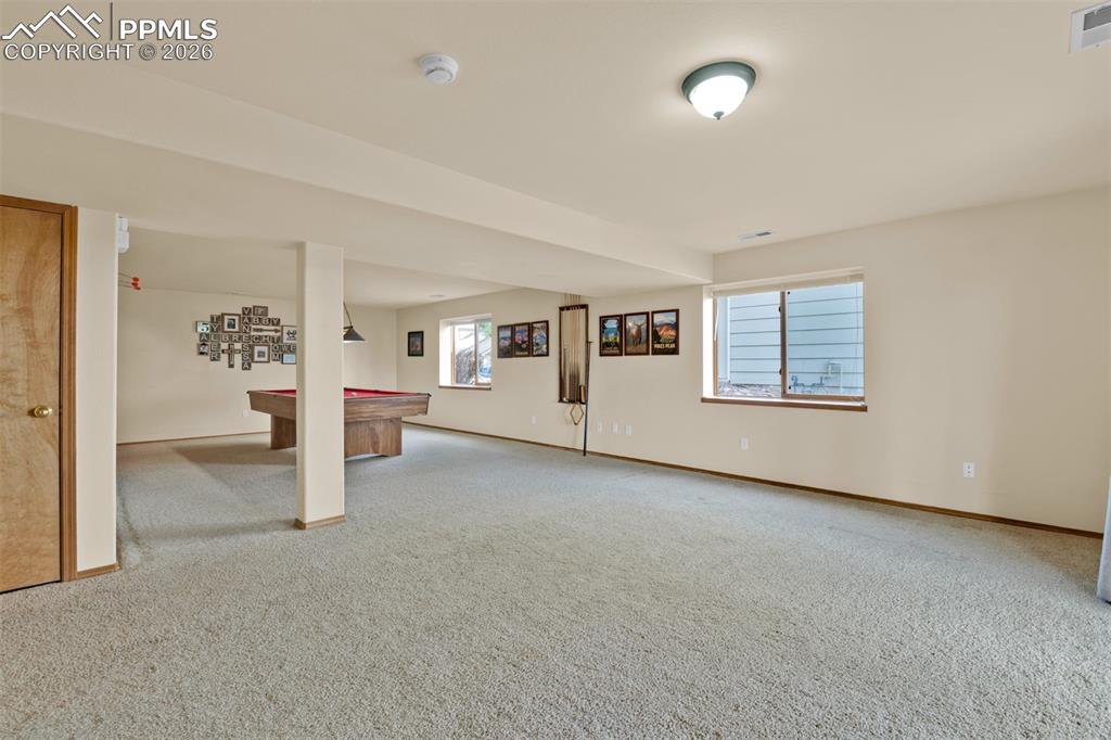 Image 33 of 50: Opposite view of garden level basement with lots of rec or media options.