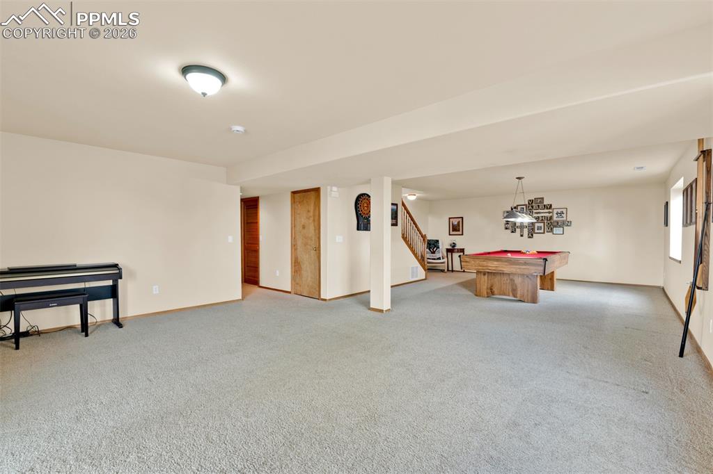 Image 34 of 50: Basement area showing hallway to Large bedroom with private bathroom and to