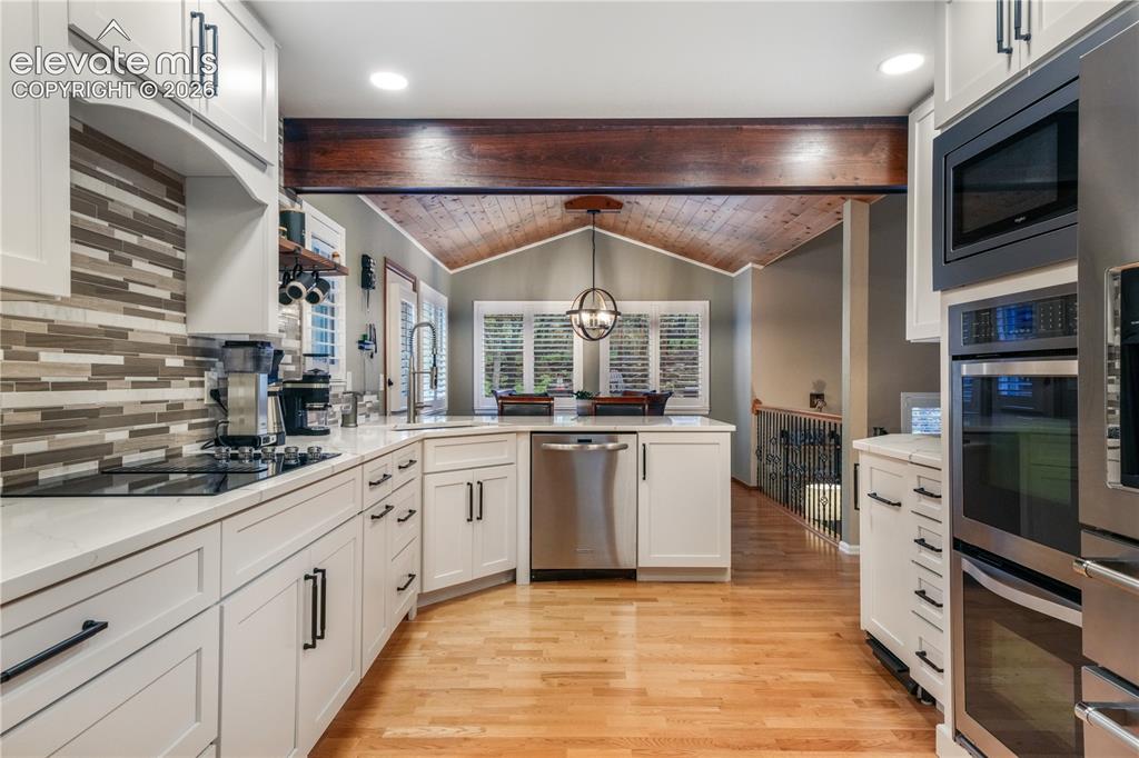Image 10 of 50: Upper living room with large windows and access into kitchen and formal din