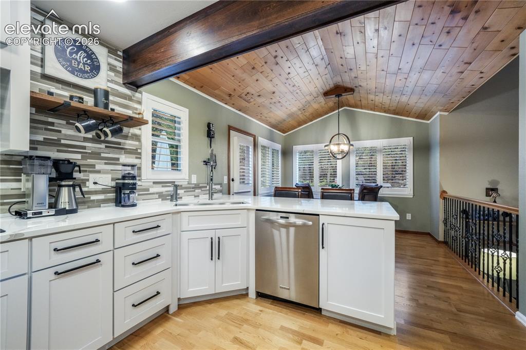 Image 11 of 50: Upper living room with large windows and access into kitchen and formal din