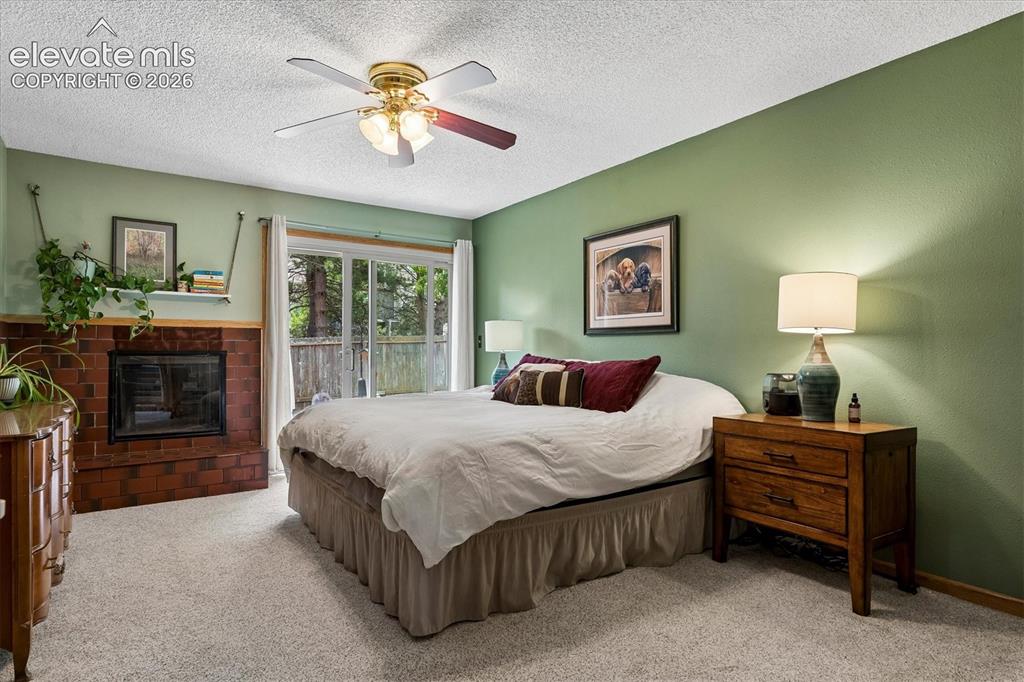 Image 13 of 30: Primary bedroom with ensuite full bath, walk-in closet and sliding door to