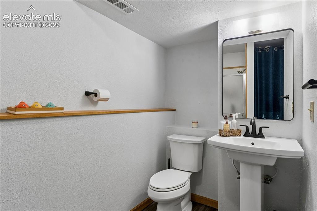 Image 20 of 30: 3/4 bathroom in basement with new flooring and toilet.
