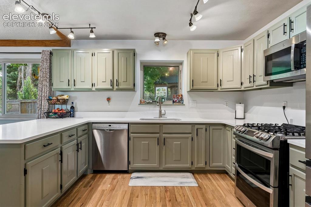 Image 4 of 30: Freshly updated kitchen with new quartz countertops, painted cabinets, hard