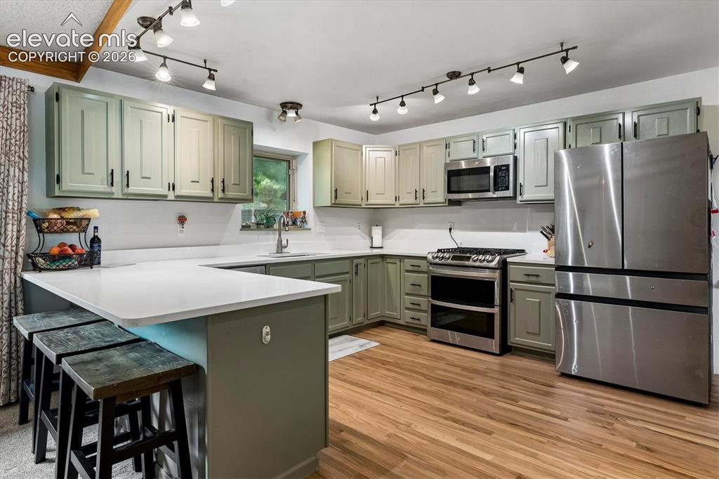 Image 6 of 30: Freshly updated kitchen with new quartz countertops, painted cabinets, hard