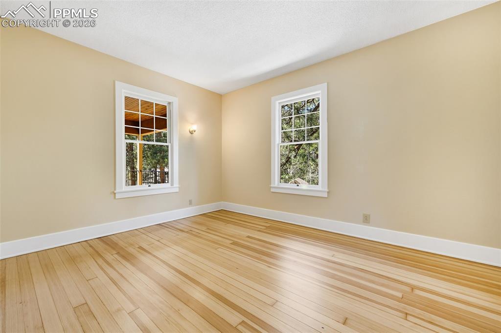 Image 22 of 47: Spacious Primary Bedroom - Wood Flooring - Main Level