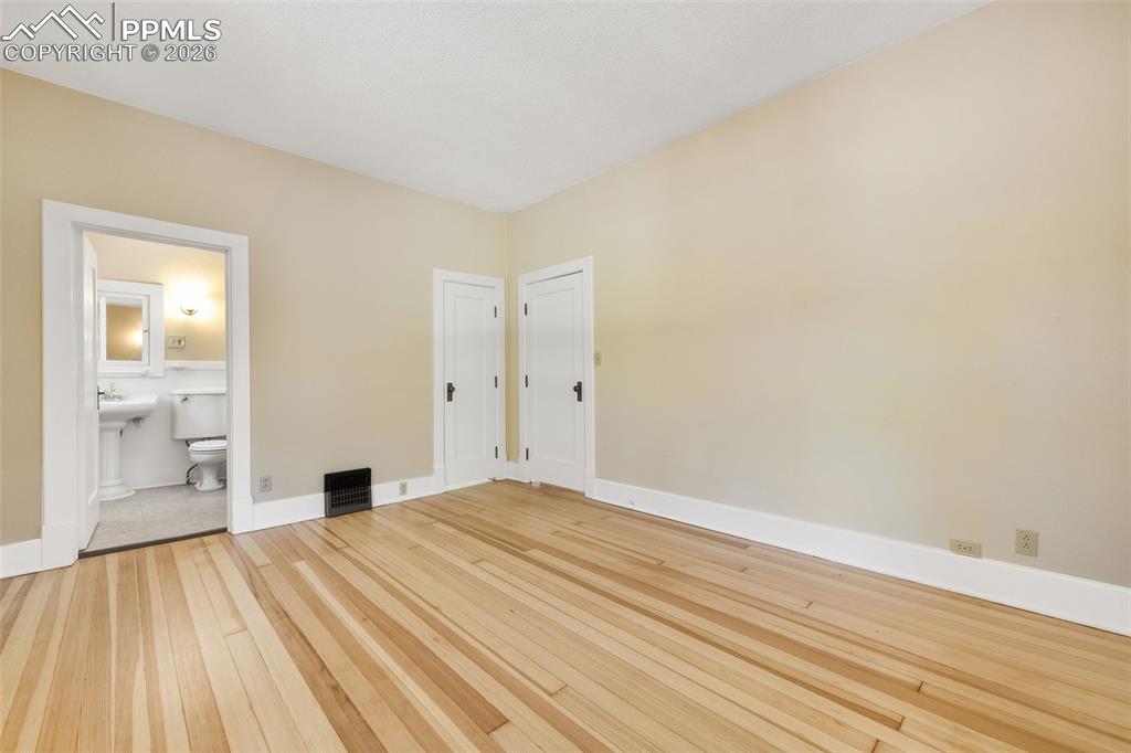 Image 23 of 47: Primary Bedroom With View Into Primary Bathroom