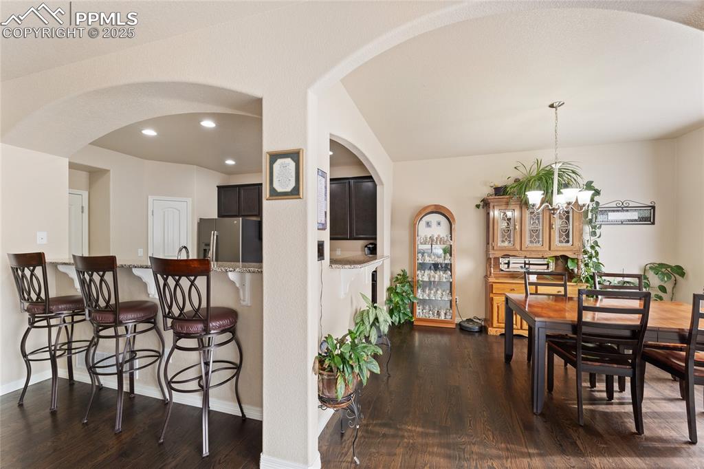 Image 10 of 38: Dining space and breakfast bar with wood floors