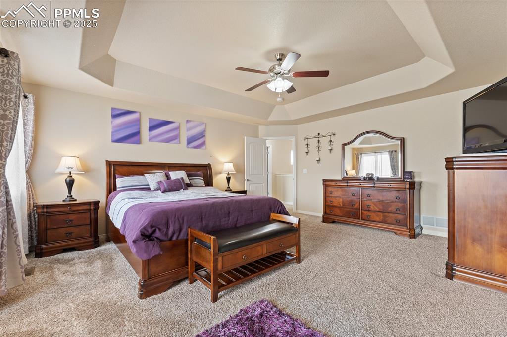 Image 19 of 38: Huge primary bedroom with a raised ceiling, double sided fireplace and sitt