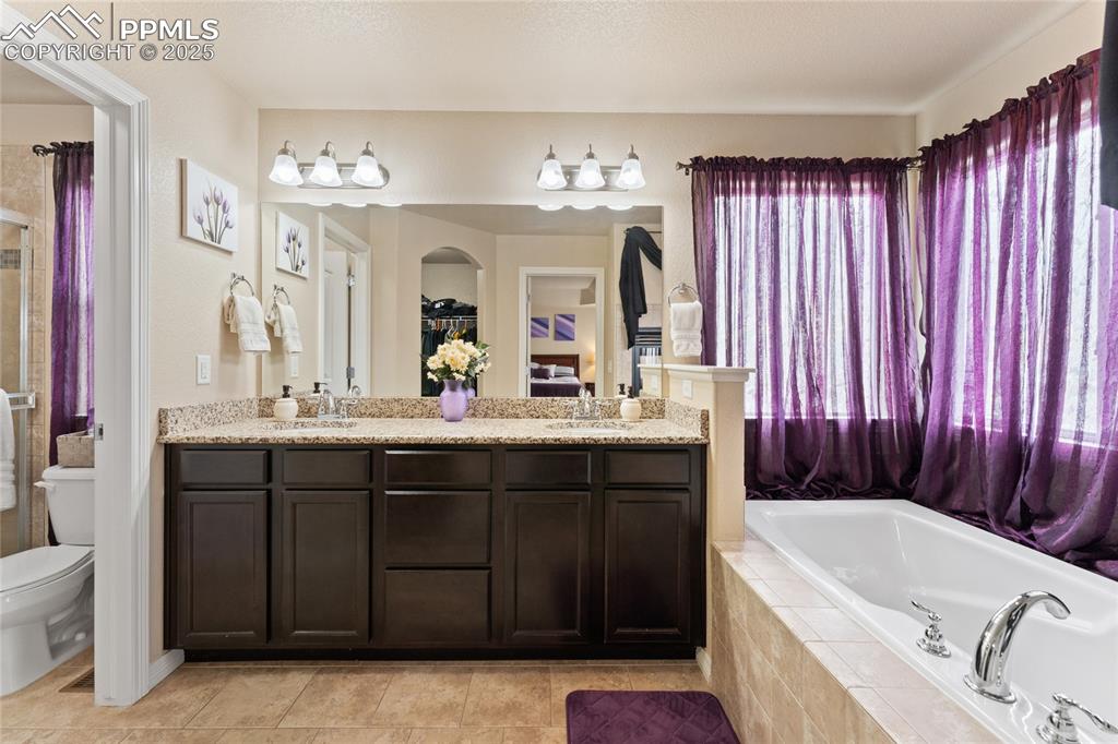 Image 21 of 38: 5 piece bathroom with a garden tub, double vanity w granite counters, tile