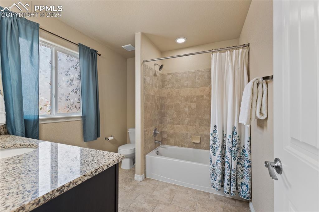 Image 27 of 38: Upstairs Bathroom with granite counters, shower / bath combination and tile