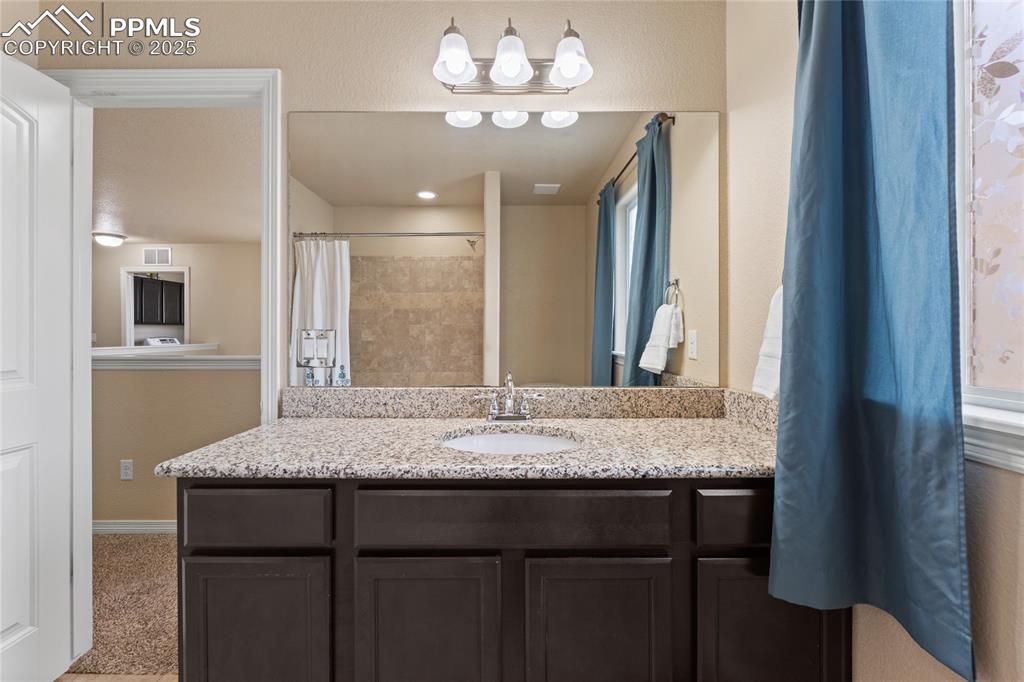 Image 28 of 38: Upstairs Bathroom with granite counters, shower / bath combination and tile
