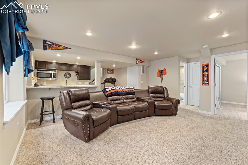 Image 32 of 38: Basement family room with wet bar