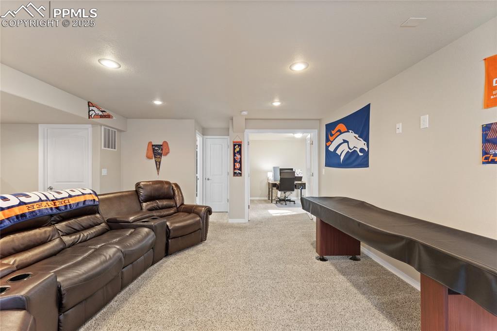 Image 34 of 38: Basement family room with wet bar