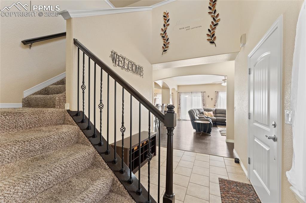 Image 5 of 38: Stairway with arched walkways and tile patterned floors