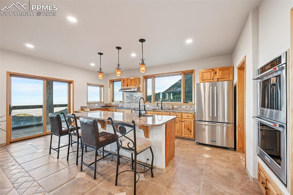 Image 14 of 50: Open concept kitchen with a walk out, granite countertops, an island with b