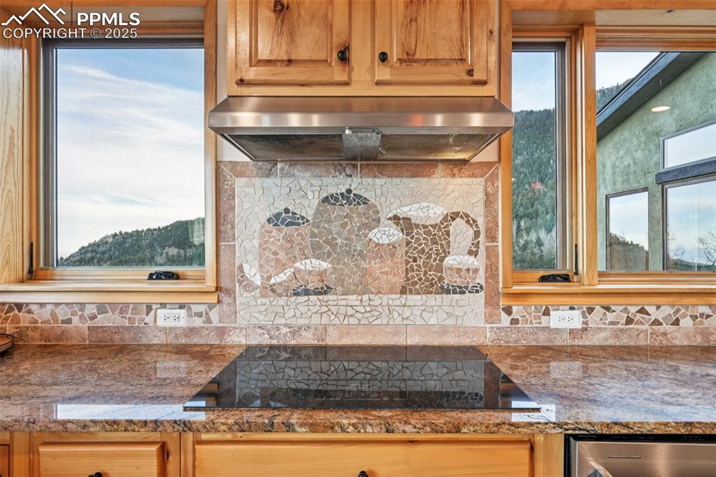 Image 15 of 50: Kitchen cooktop highlighting the custom backdrop with the mountain views be