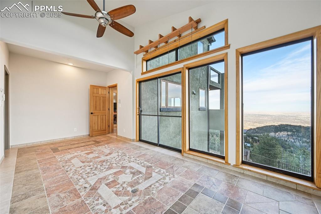 Image 19 of 50: Sun room on the main level equipped with drainage and views!