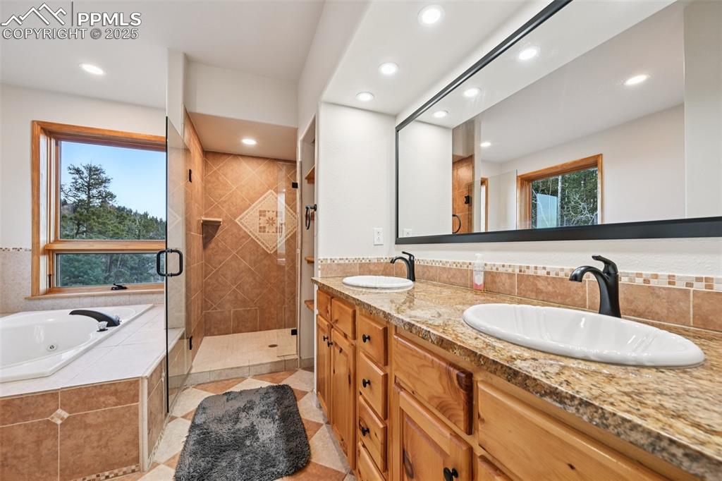 Image 24 of 50: 5 piece en suite primary bathroom with jetted tub, dual sinks, stand in sho