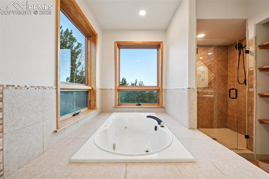 Image 25 of 50: Primary bathroom highlighting the jetted tub with private mountain views ou