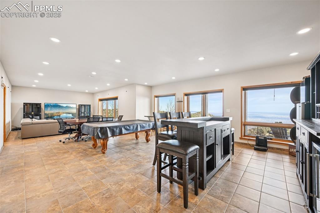 Image 38 of 50: Recreation room with dry bar, pool table, sitting area and a walk out