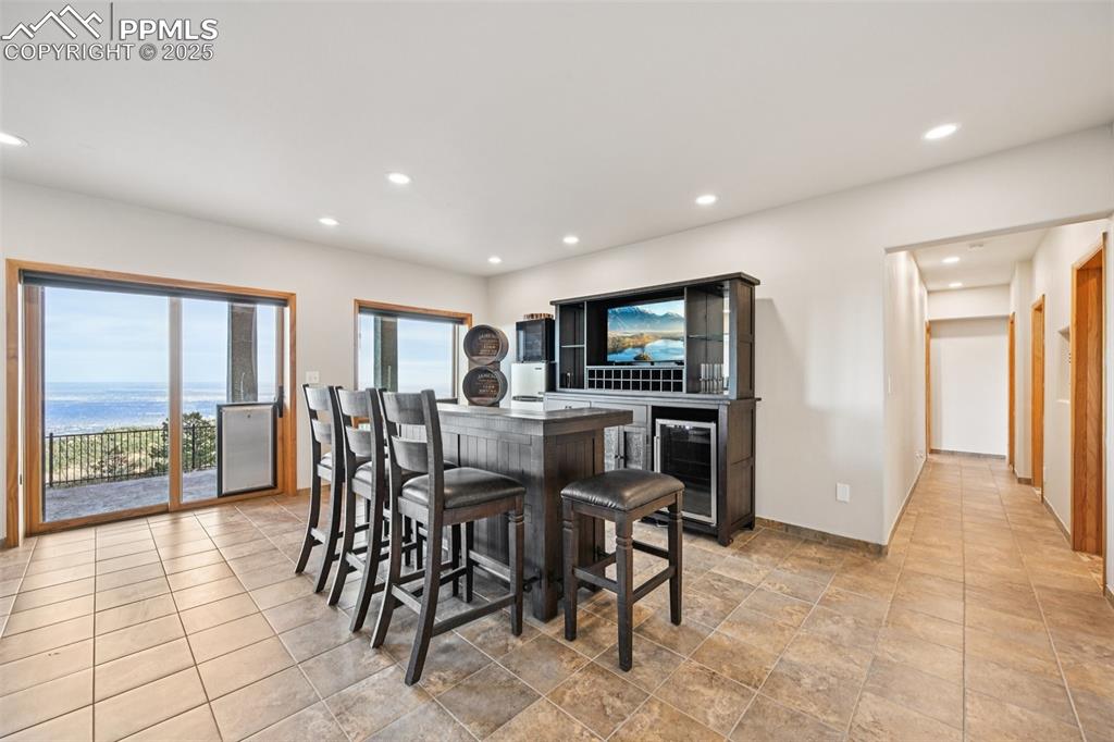 Image 40 of 50: Recreation room with dry bar, pool table, sitting area and a walk out