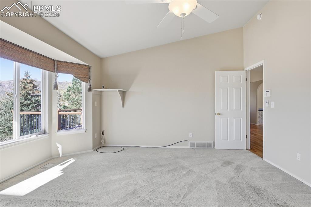 Image 34 of 50: Spare room with carpet floors, ceiling fan, lofted ceiling, and arched walk