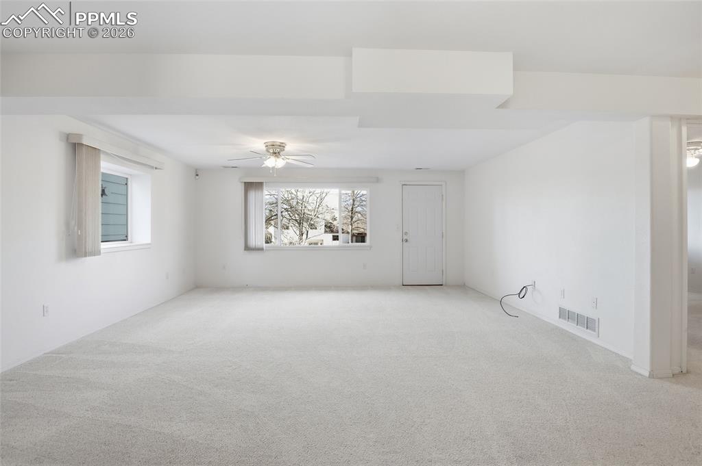 Image 40 of 50: Unfurnished room with light colored carpet and ceiling fan