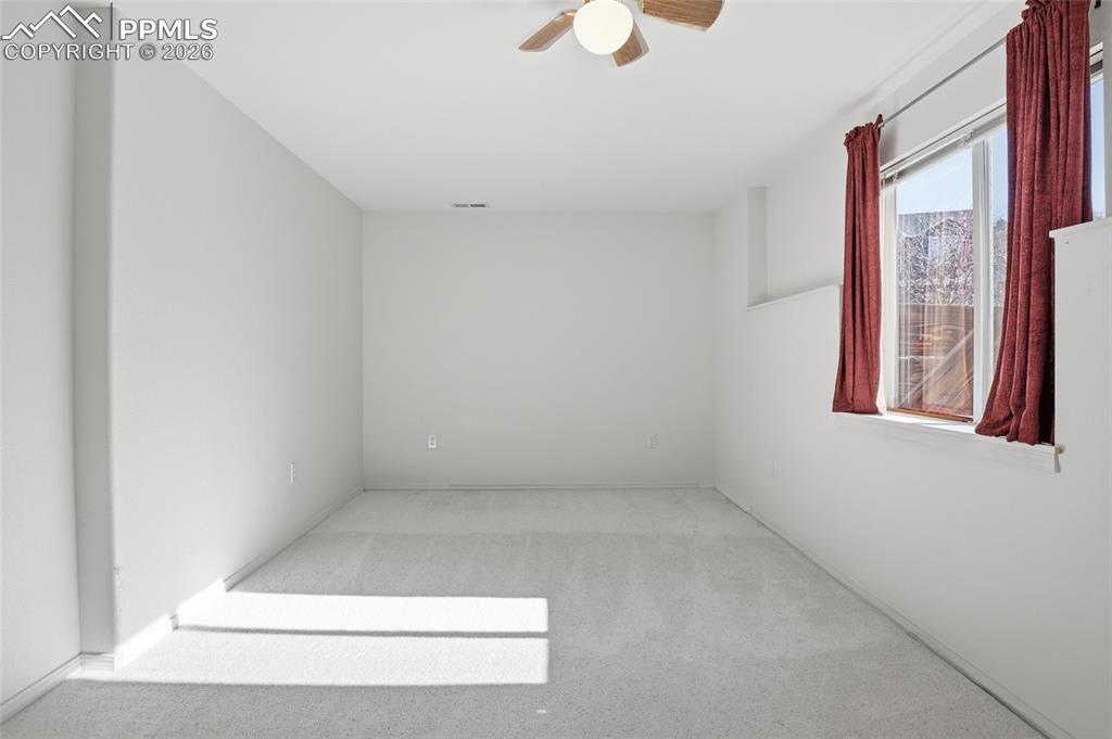 Image 42 of 50: Unfurnished room with light carpet and ceiling fan