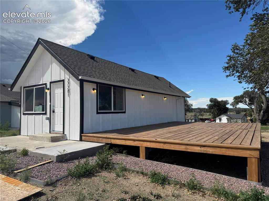 Image 3 of 26: White vertical siding exterior with black trim, a dark shingle roof, and a 