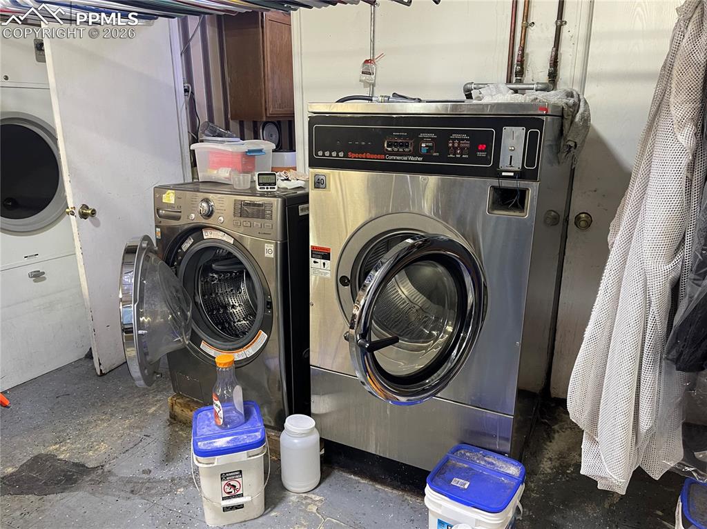 Image 7 of 11: Laundry room with concrete floors and separate washer and dryer