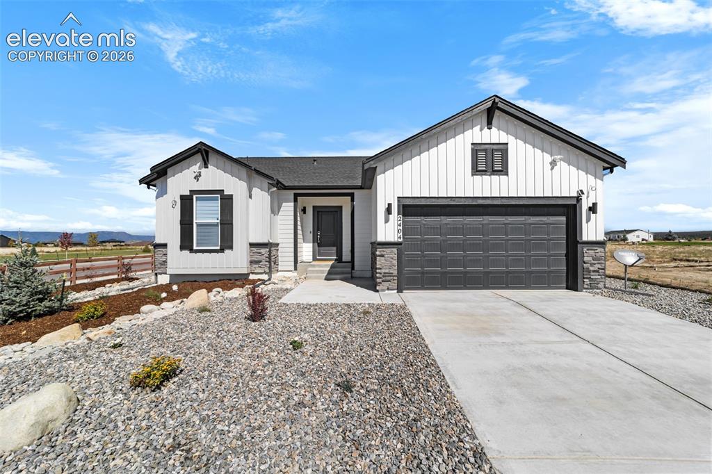 Image 1 of 38: Modern farmhouse-style exterior featuring white vertical siding and dark tr