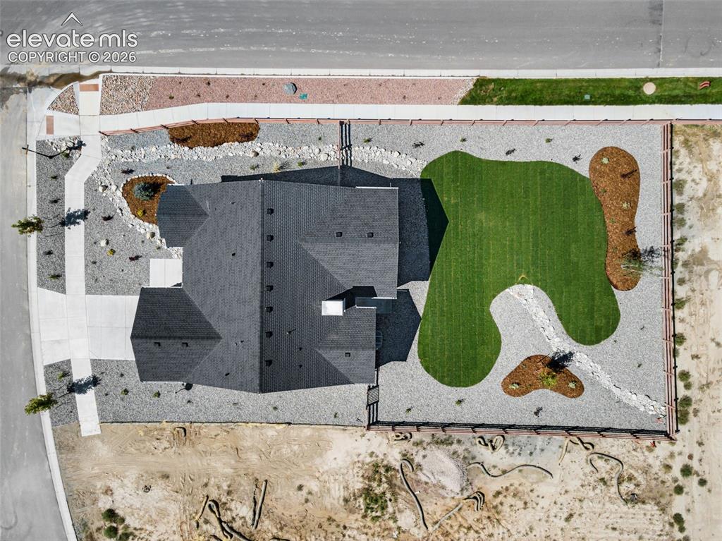 Image 13 of 38: Aerial view of a residential property featuring a dark shingle roof and a s