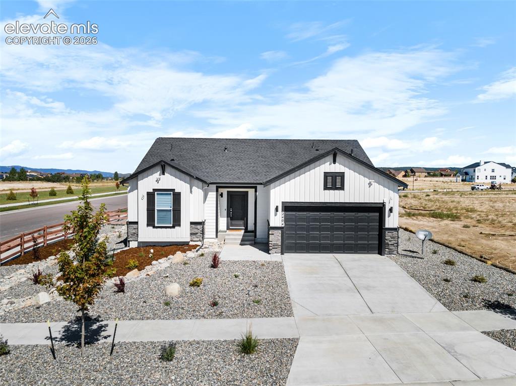 Image 18 of 38: Modern farmhouse-style exterior featuring white vertical siding with dark t
