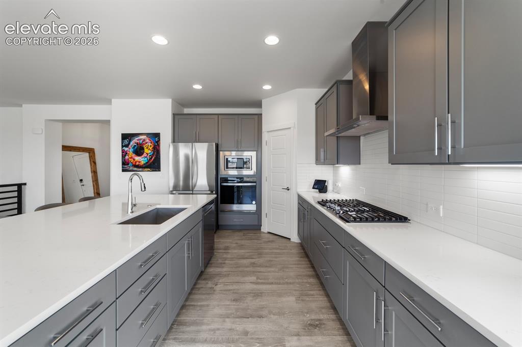Image 19 of 38: Contemporary kitchen with light gray cabinetry, stainless steel appliances,