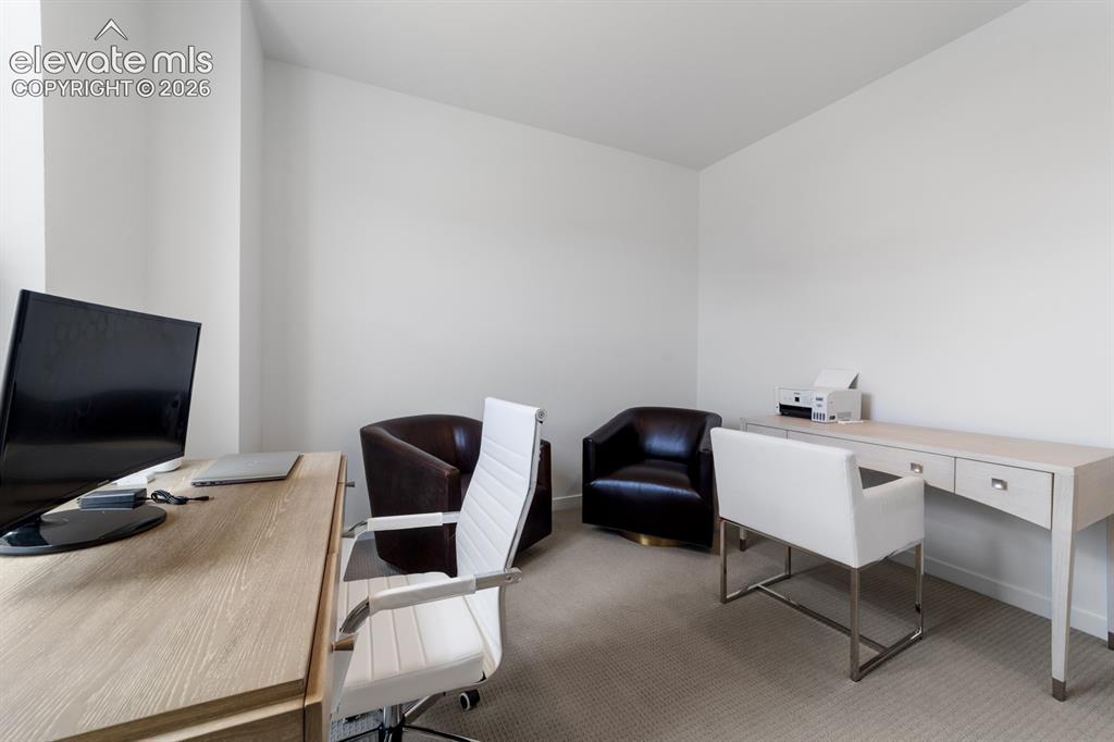 Image 27 of 38: Neutral wall finishes complement the light wood-finish desk with storage dr