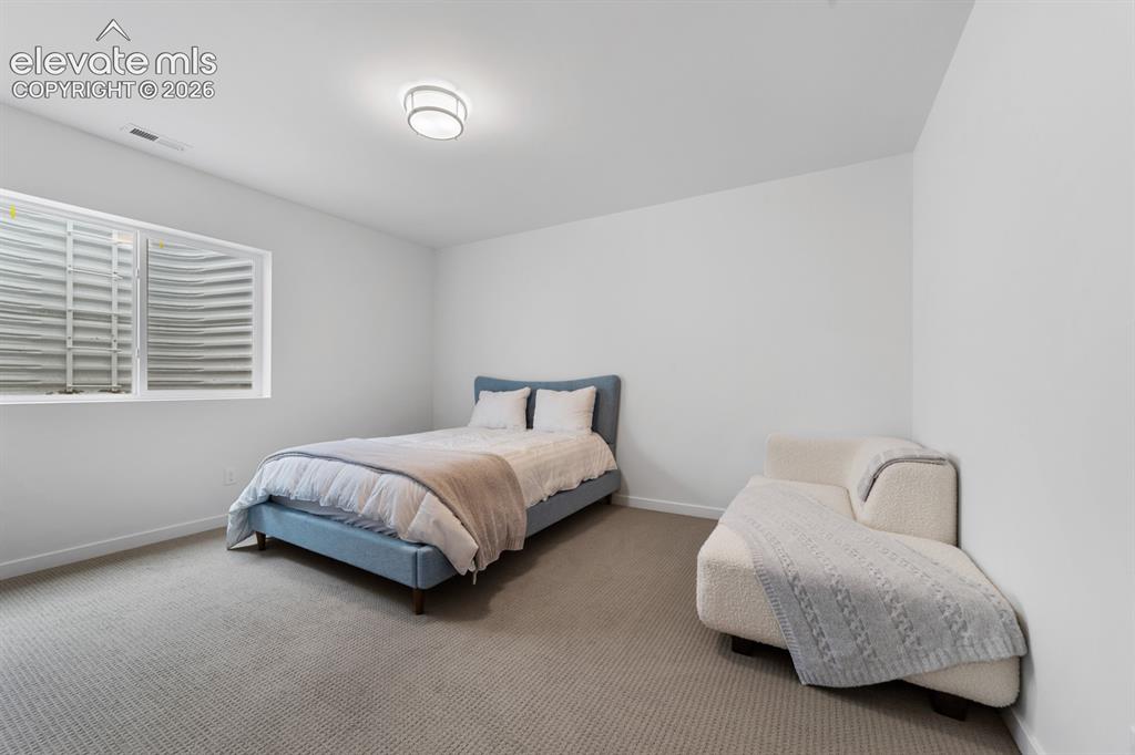 Image 33 of 38: Carpeted room featuring a white egress window with a white frame and a flus